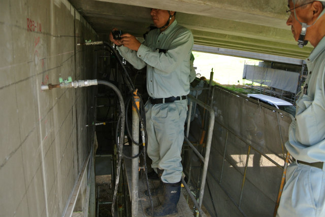 足場上で現場説明をしている、 江良さん | ASR 補修工事 現場見学会(山内高架橋) | 活動・講演・見学会報告 | 一般社団法人コンクリートメンテナンス協会